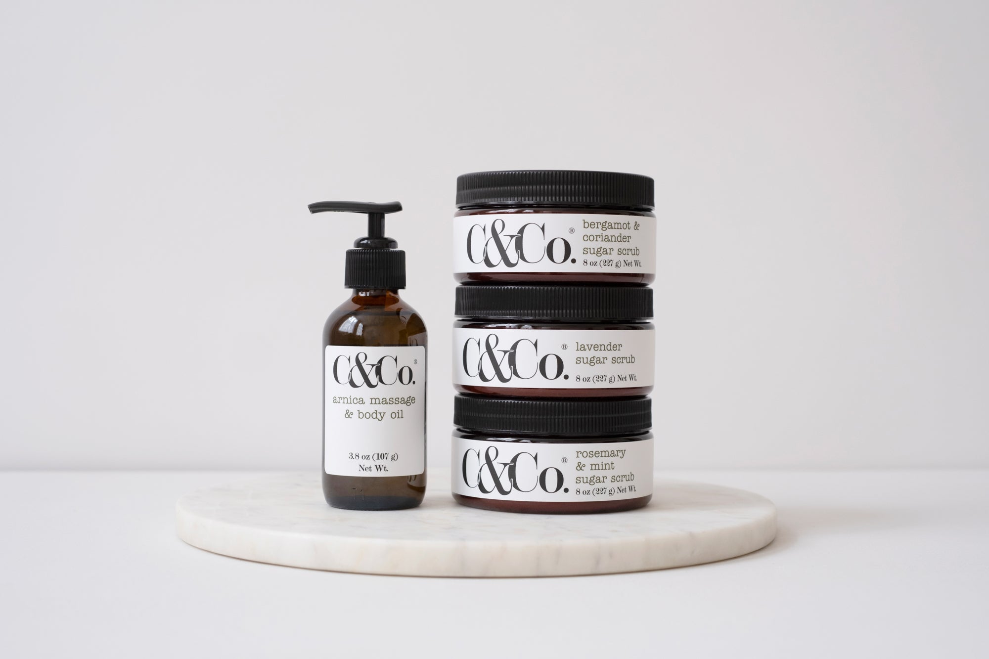 Bottle of massage oil and 3 body exfoliants
