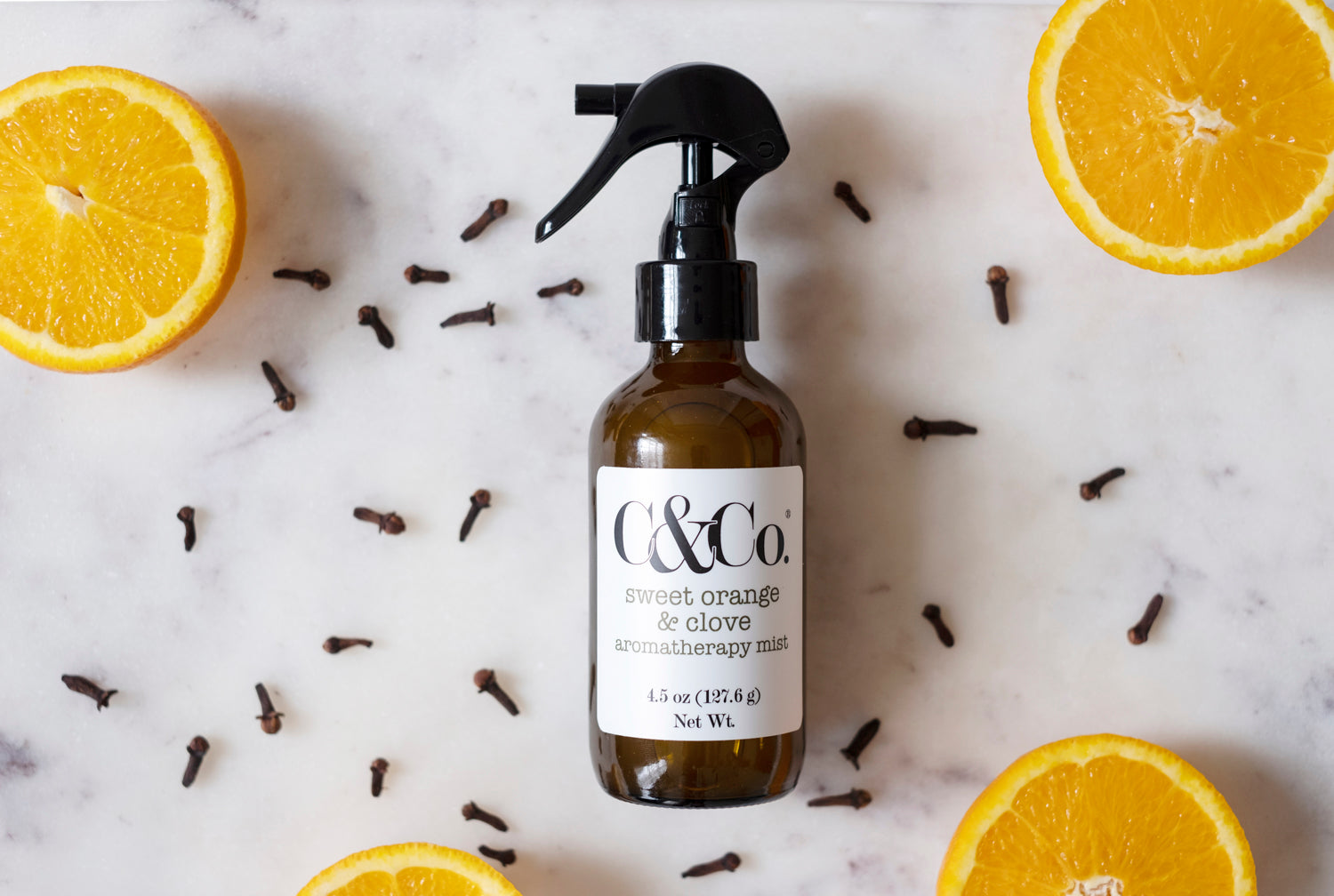 Bottle of aromatherapy mist with orange slices and clove